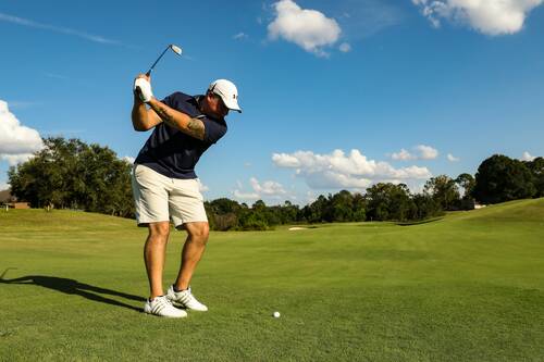 Ein Golfer holt auf dem Golfplatz zum Schlag aus.