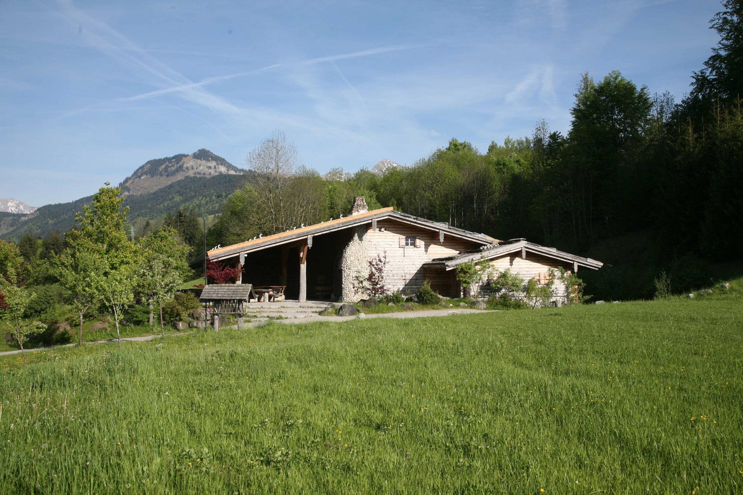 Die Sonnenkopfhütte des AllgäuSternHotels mit Almwiese und Berggipfel.