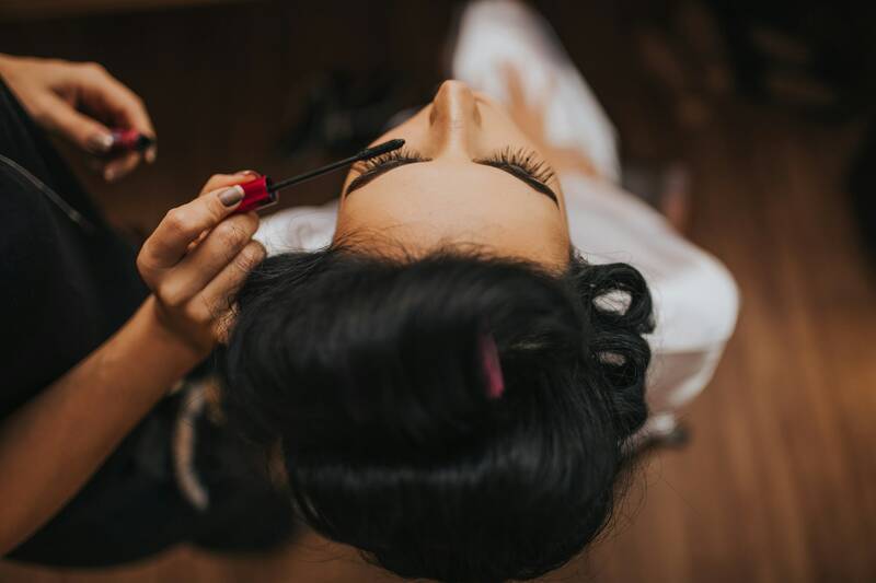 Einer dunkelhaarigen Frau werden Ihre Wimpern professionell behandelt.